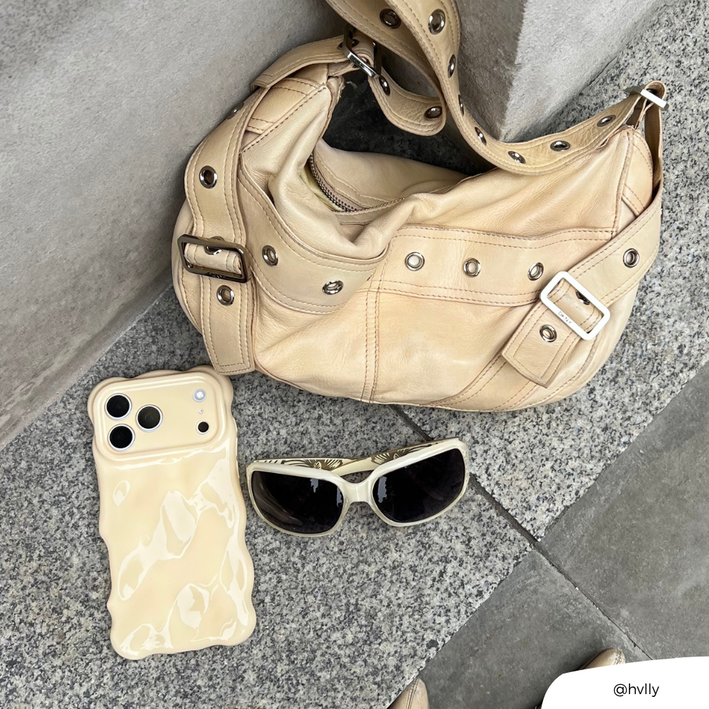 Flatlay image of yellow bag and sunglasses next to 3D Bubble Butter Yellow Phone Case