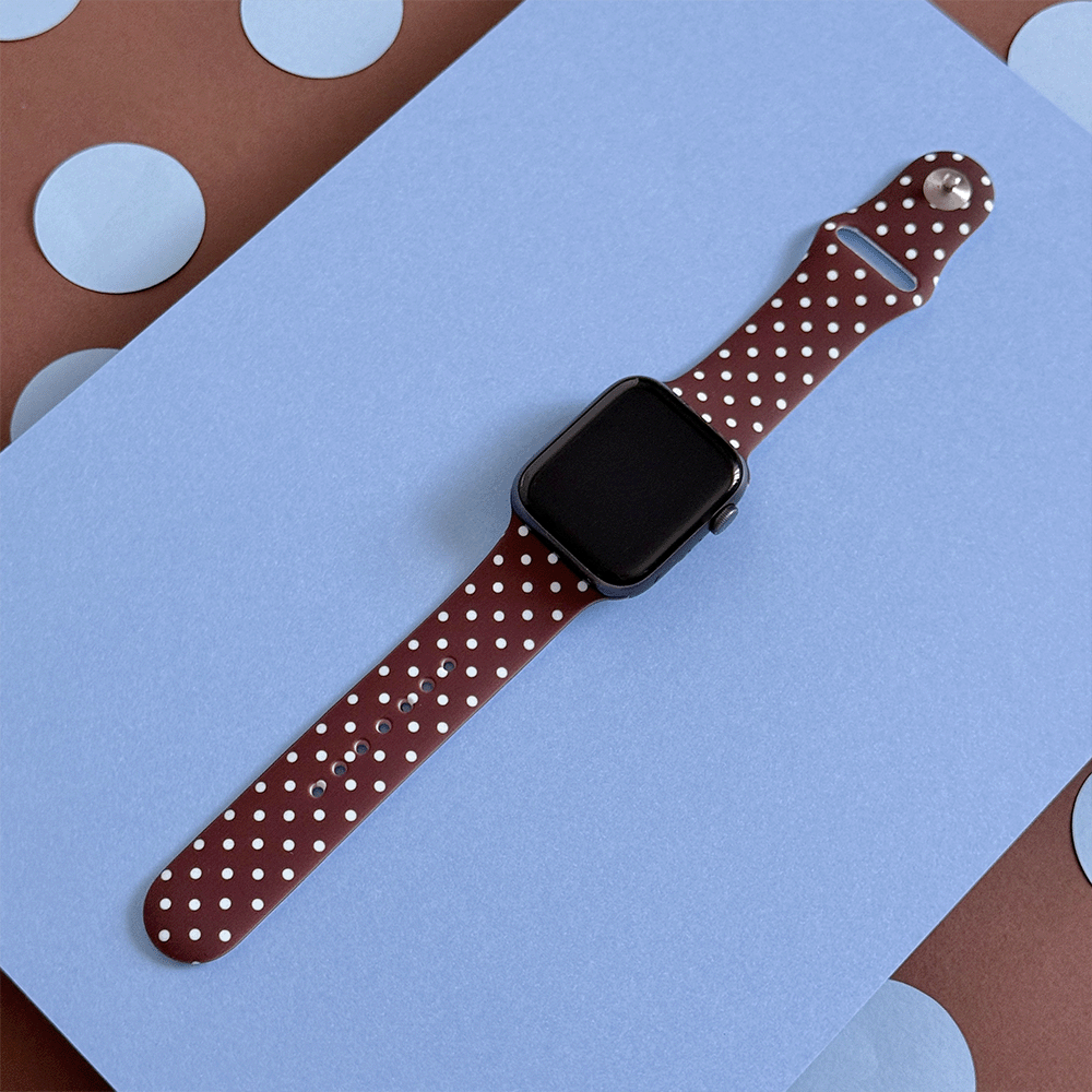 A smartwatch with a floral band is centered on a red rectangular background, surrounded by decorative red roses arranged in a symmetrical pattern.