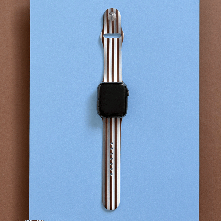 Apple Watch Strap with brown and white vertical stripes on a blue background.