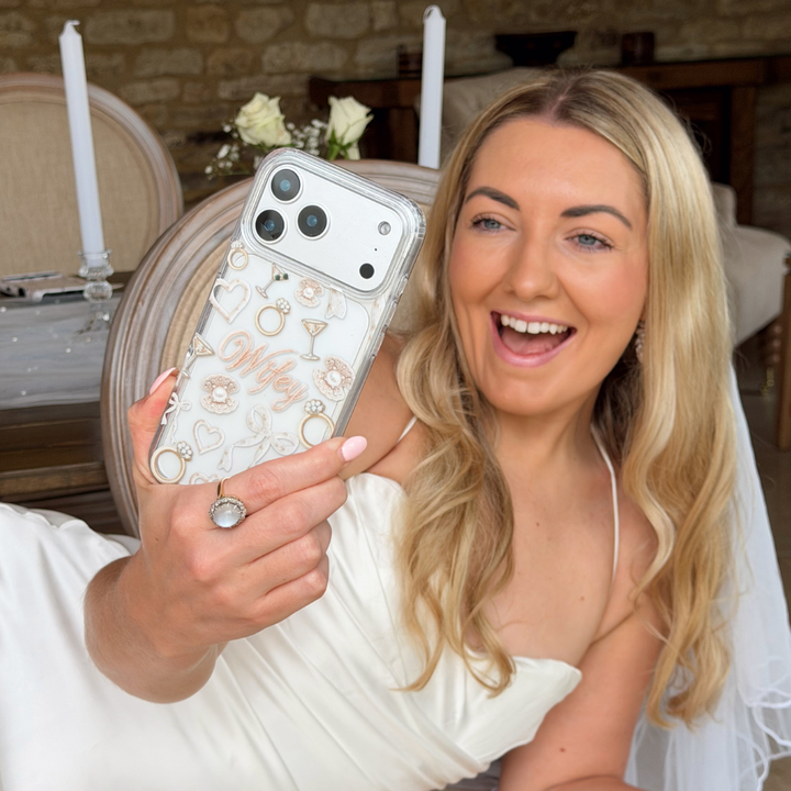 Woman holding a phone case with decorative elements in a wedding setting