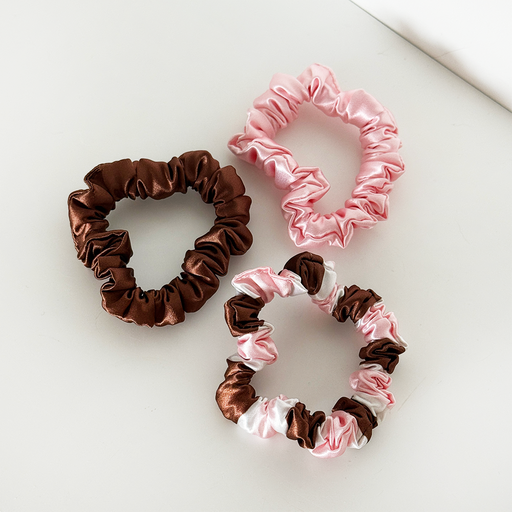 Scrunchie Set featuring three satin hair scrunchies in chocolate brown, blush pink and a brown, pink and white striped design, photographed on a white background.