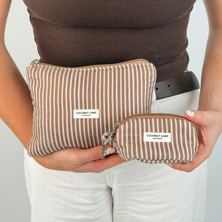 Girl holding two chestnut stripes makeup bags