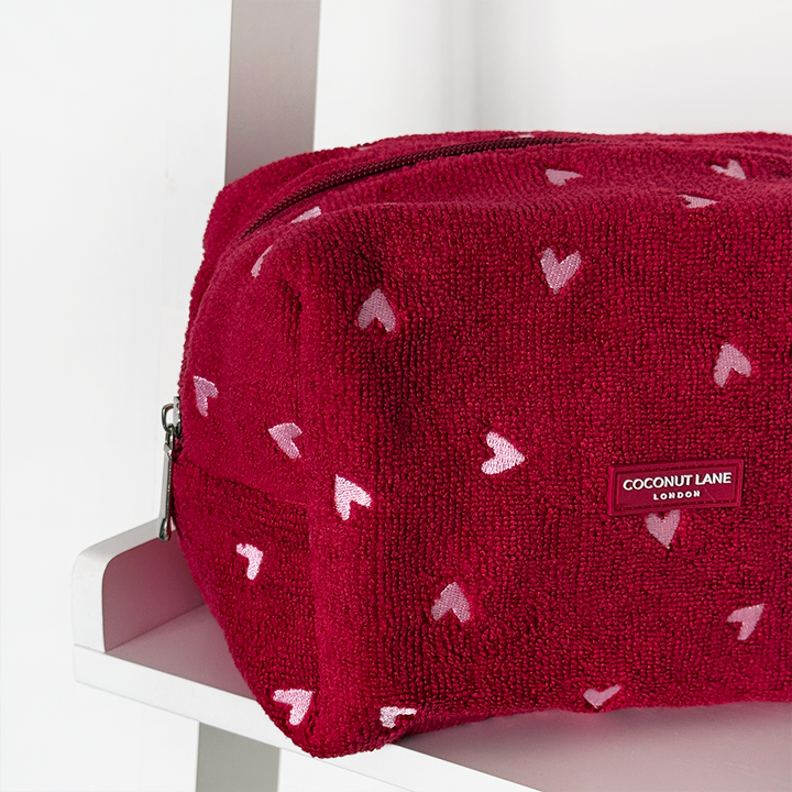 Red textured pouch with heart patterns on a white background
