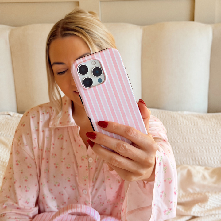Girl taking selfie in cosy bed in pink outfit with Powder Stripes Tough Phone Case