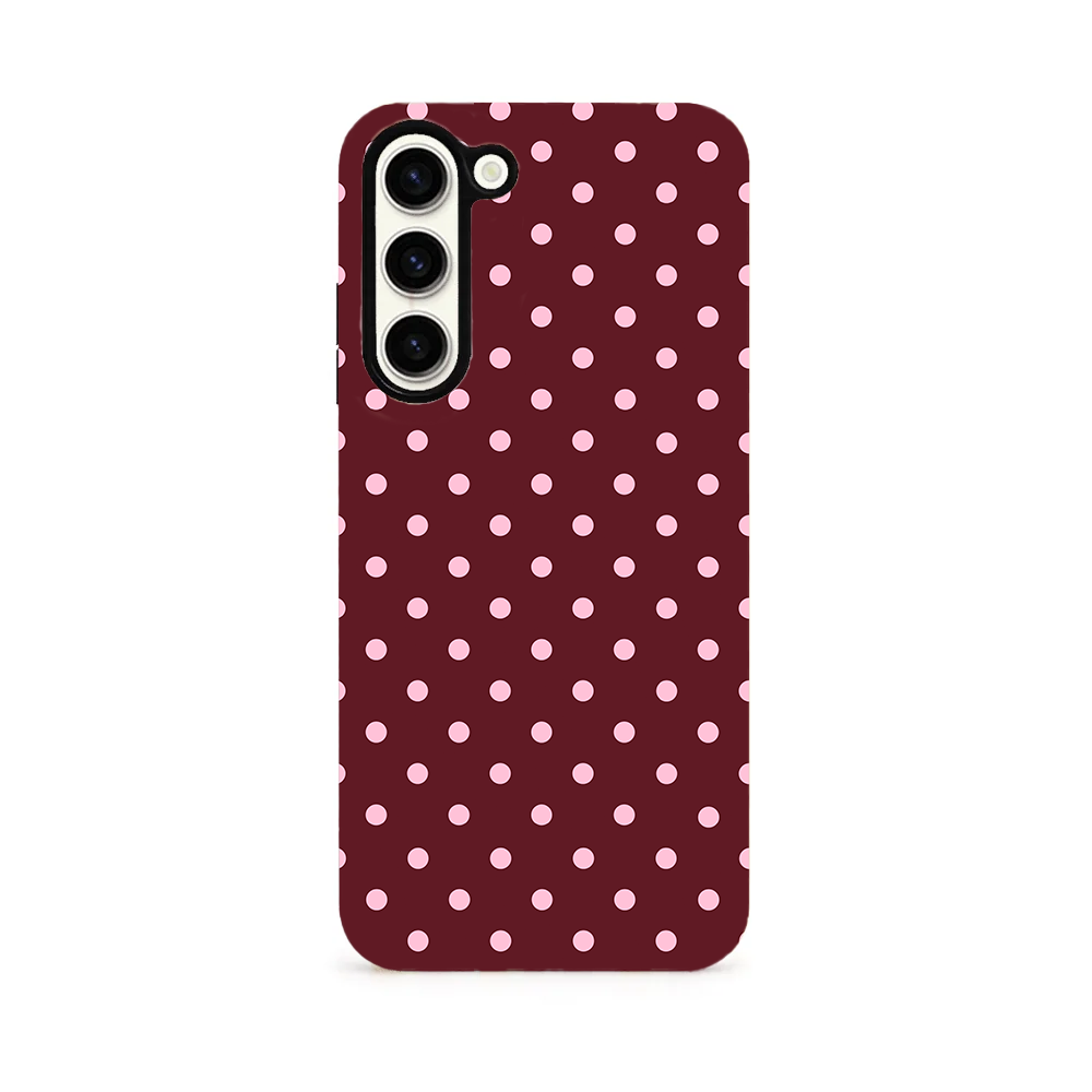 A dual-layer phone case with brown polka dots and pink spots on a white background.