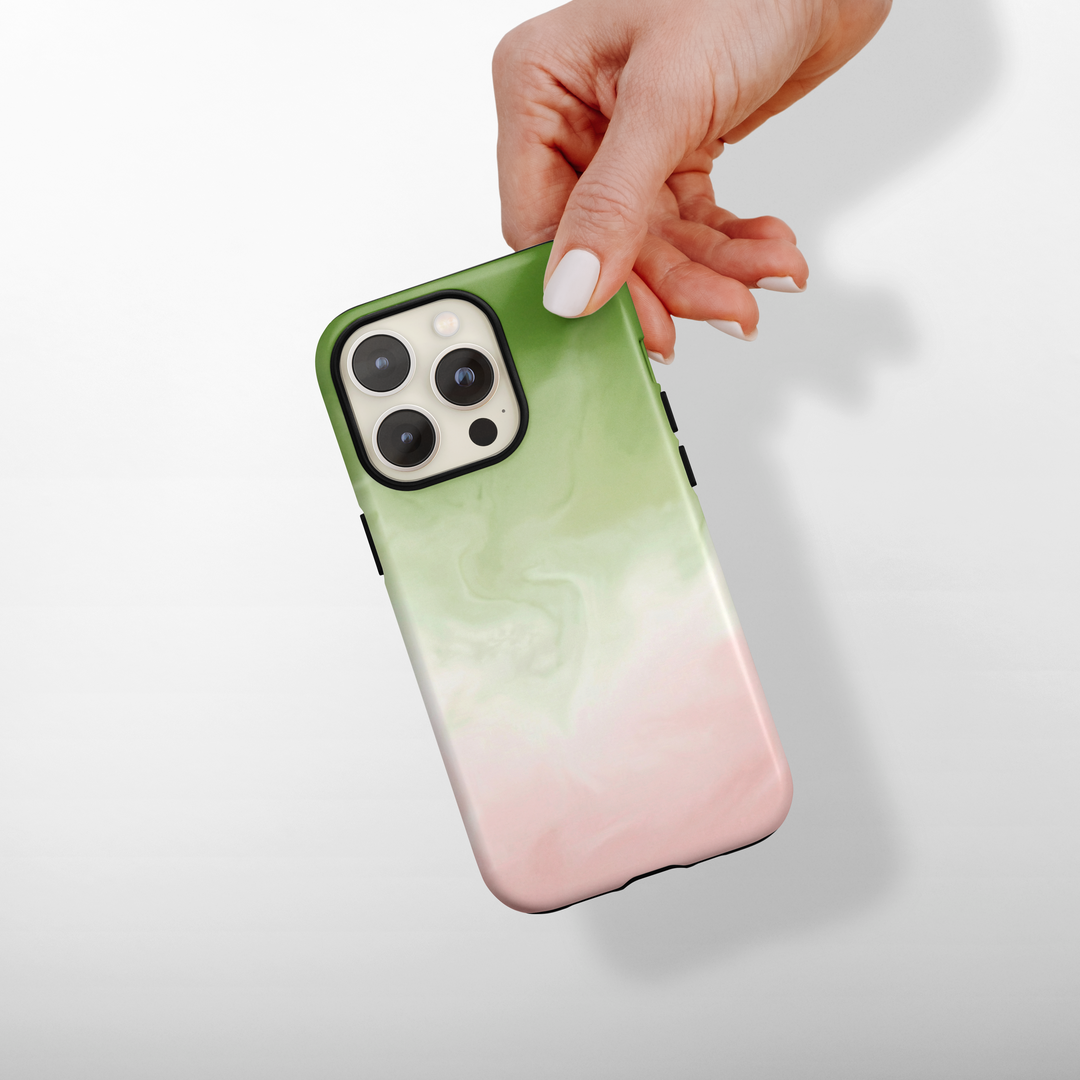 Phone case with matcha and pink gradient design held by a hand on a light background