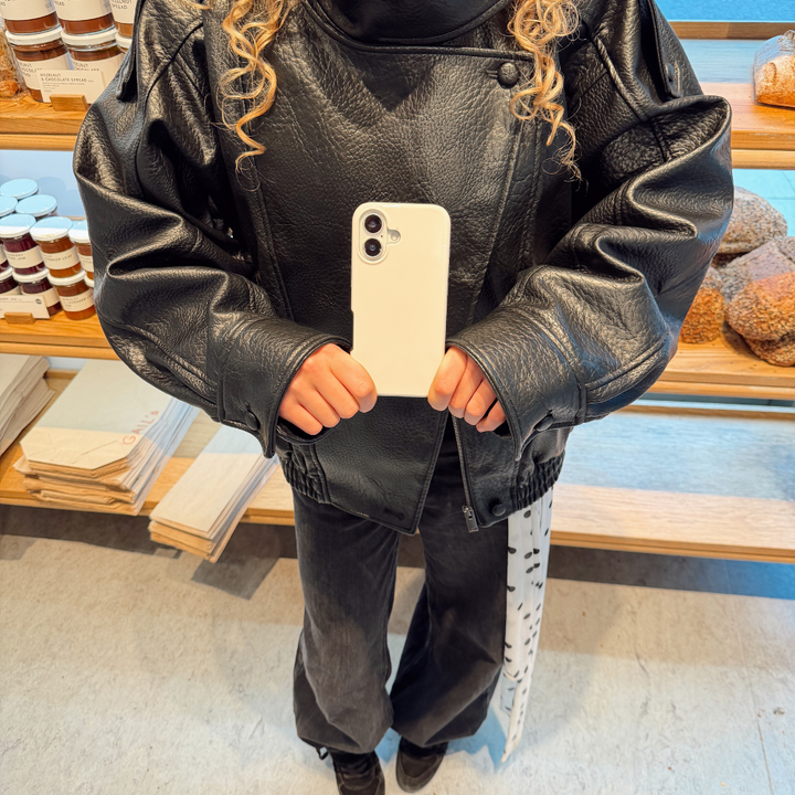 Girl in the bakery posing with the Tough Phone Case in Cloud Dancer