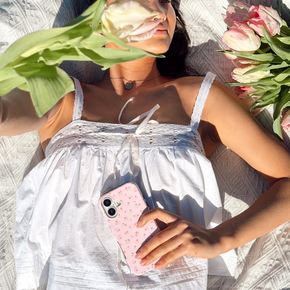 Girl at a picnic in the spring holding tough phone case ditsy floral pink