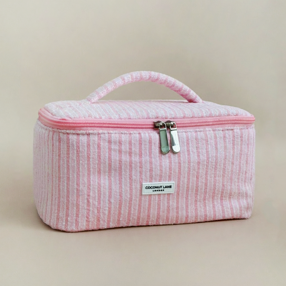 Pink striped cosmetic bag with Coconut Lane brand label on a beige background