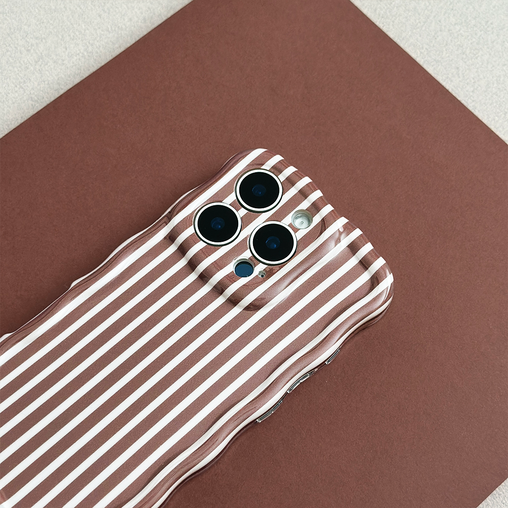 Coconut Lane wavy phone case with chestnut stripes, shown on a brown surface next to a smartphone.