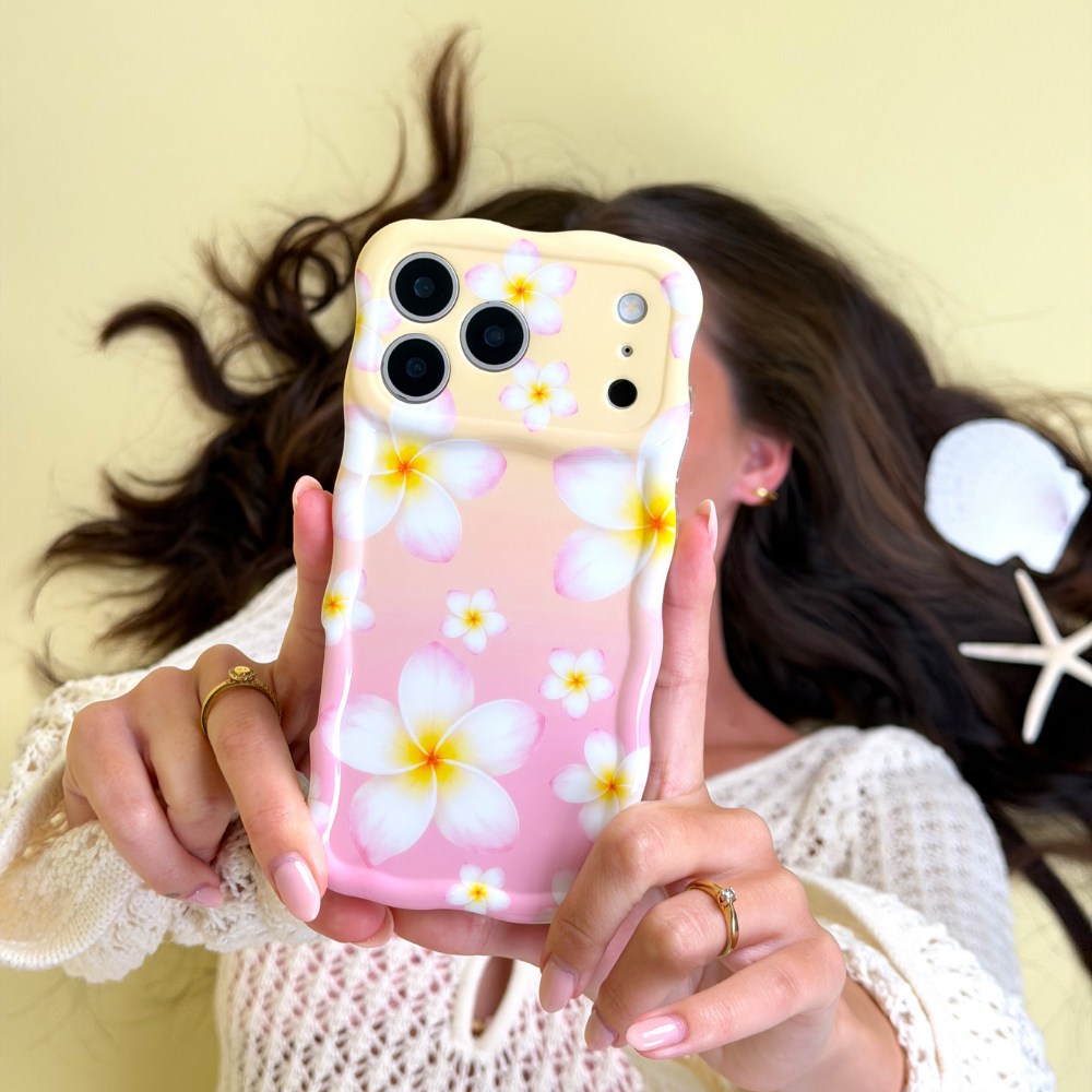 Girl holding a phone case with floral design against a yellow background