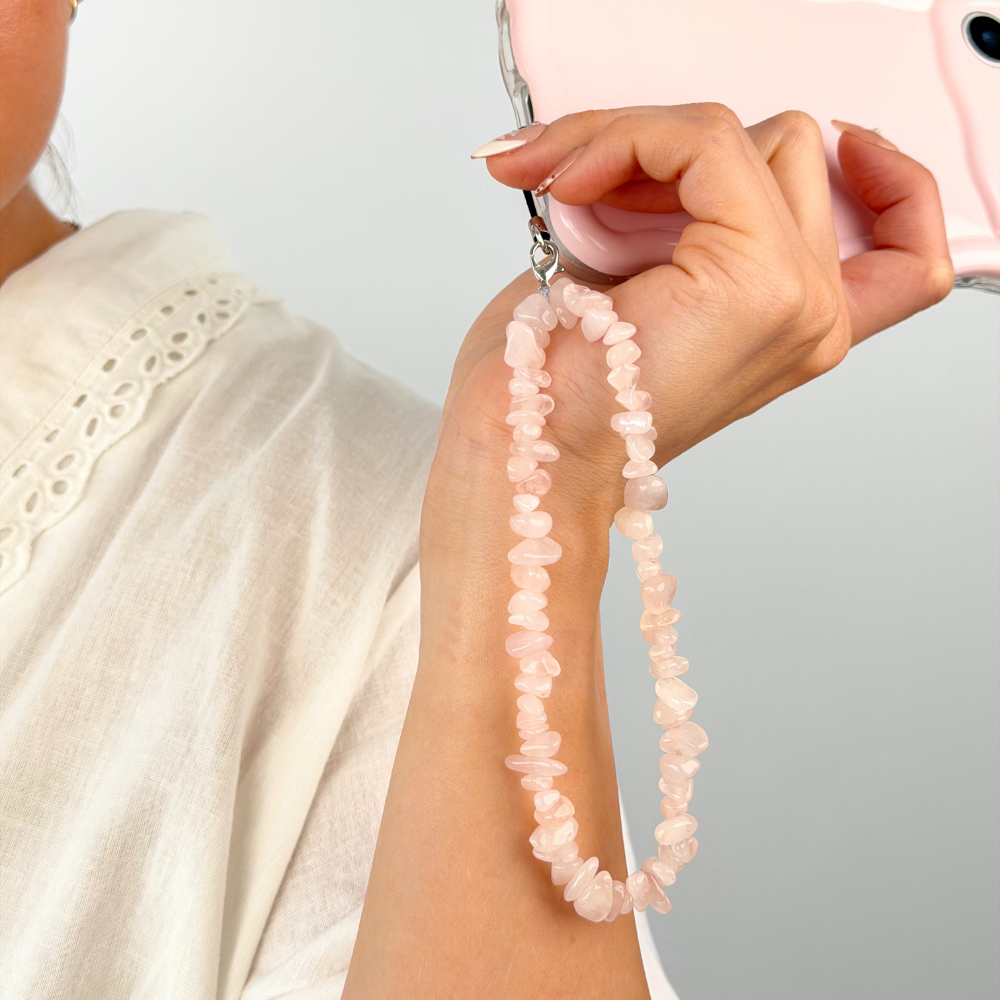 Girl with her rose quartz phone strap in a studio shoot