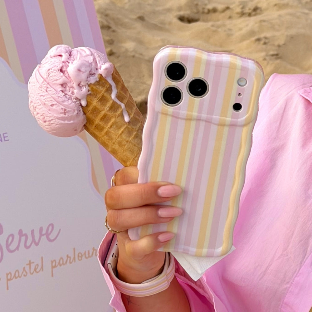 Wavy pastel stripe phone case being held with pink ice cream in cone on beach