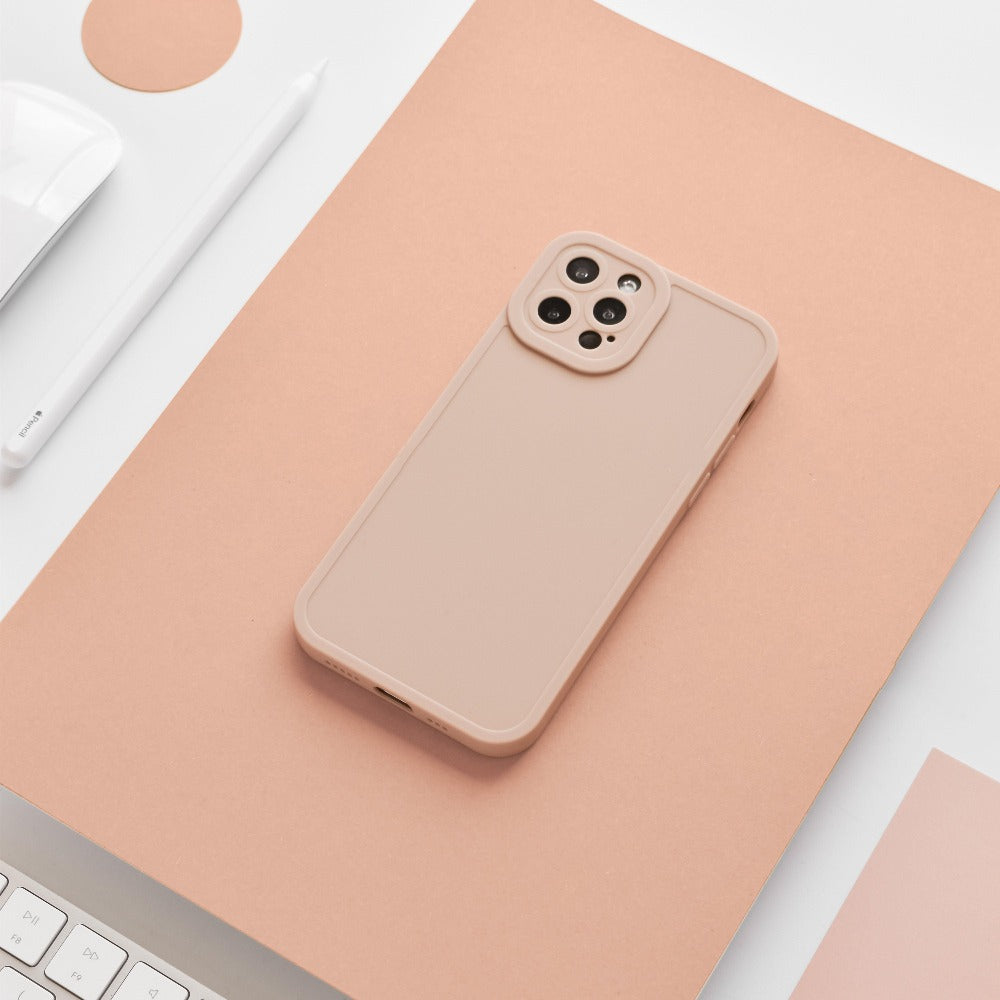 A beige smartphone with a NAKD Phone Case - Peach by Coconut Lane is placed on a light peach-colored surface. Around it, a white keyboard, white pencil, and part of a white mouse are visible, creating a minimalist and monochromatic aesthetic that showcases core designs and pastel favorites.